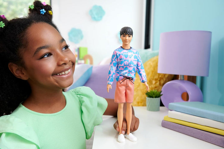 Barbie Fashionistas Ken Doll nr. 219 cu corp subțire și cămașă cu mânecă lungă cu model detașabil în roz și albastru și pantaloni scurți roz, HRH24