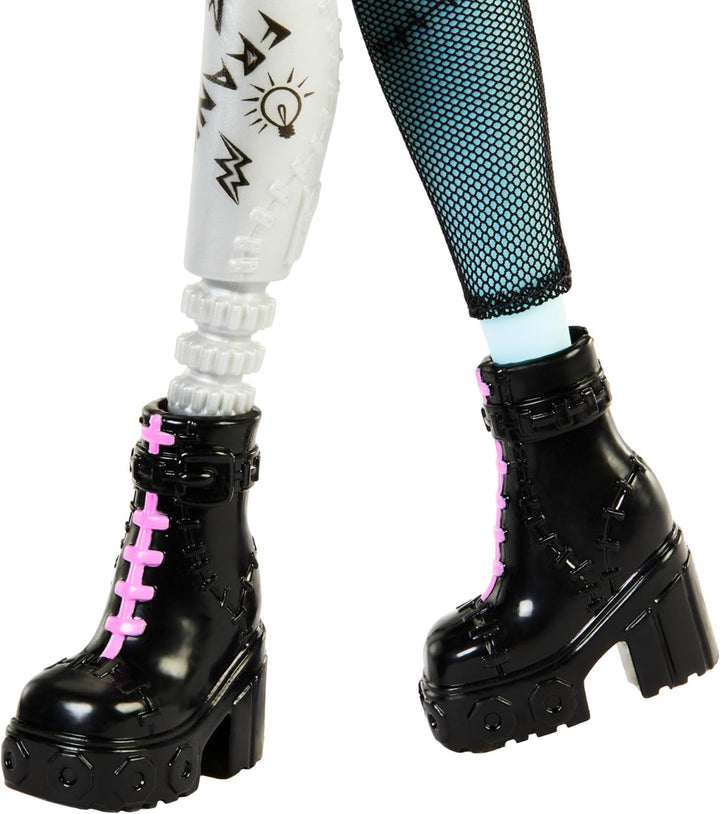 Păpușă Monster High Frankie Stone cu jachetă din denim și pantaloni scurți, include câinele Watzie și accesorii precum un rucsac, o gustare și un notebook, HXH73
