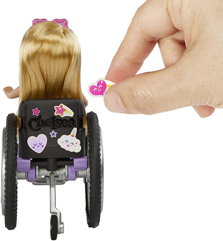 Barbie Chelsea Series, Fashionista Chelsea Doll cu păr blond, rochie, ochelari de soare, scaun cu rotile și rampă, autocolante, cadou pentru copii, jucării de la 3 ani, Hgp29